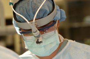 Surgeon with mask doing procedure