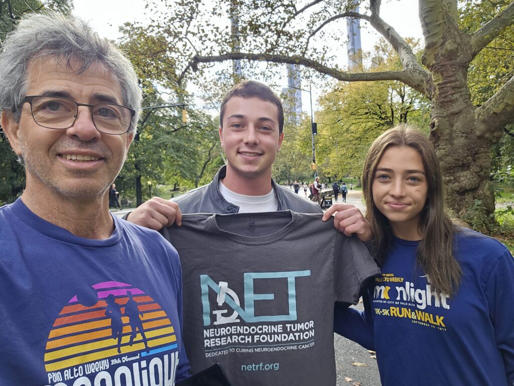 Firsty Family holds up t-shirts during walk in Central Park