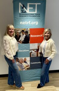 Elaine Nord and Carrie Camino standing next to a NETRF banner.