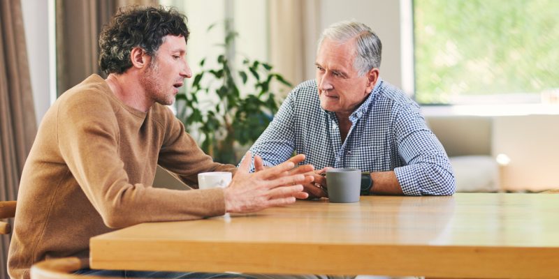 Shot of a mature man and his elderly father having coffee and a chat at home